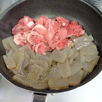 こんにゃくと豚肉を炒める様子