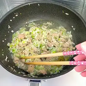 水と調味料も入れて炒める様子