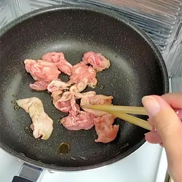 ごま油で豚こま肉を炒める様子