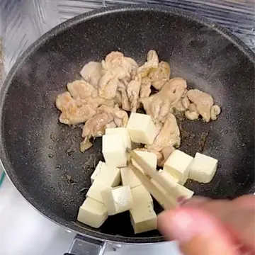 豚こま肉と豆腐を炒める様子