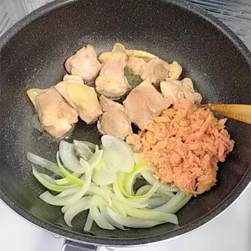 鶏もも肉と玉ねぎとツナを炒める様子