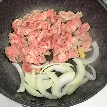 豚こま肉と玉ねぎを炒める様子